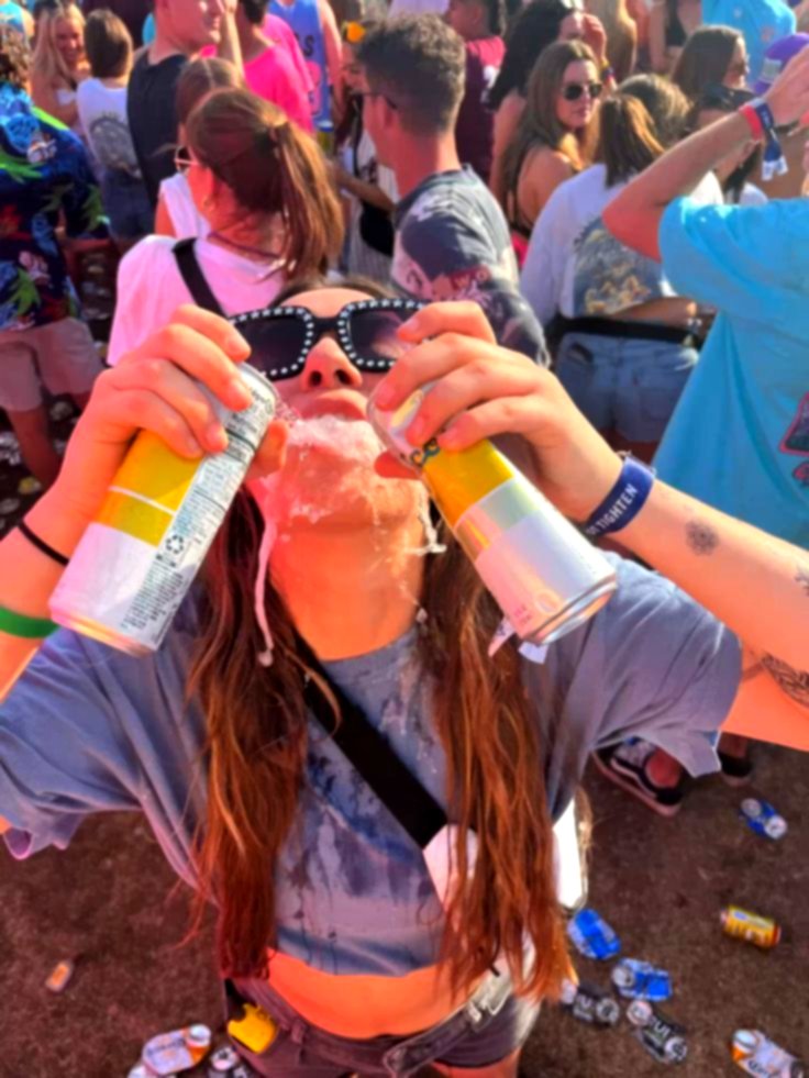 Un fêtard, des canettes à la main, au milieu de la foule